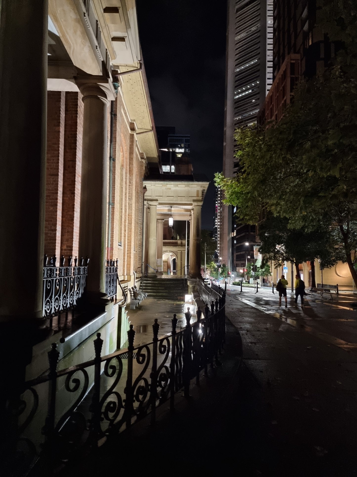 Dawn twilight ; the lighting casts down from St James' church, revealing the ornate fencing curving around the building.
