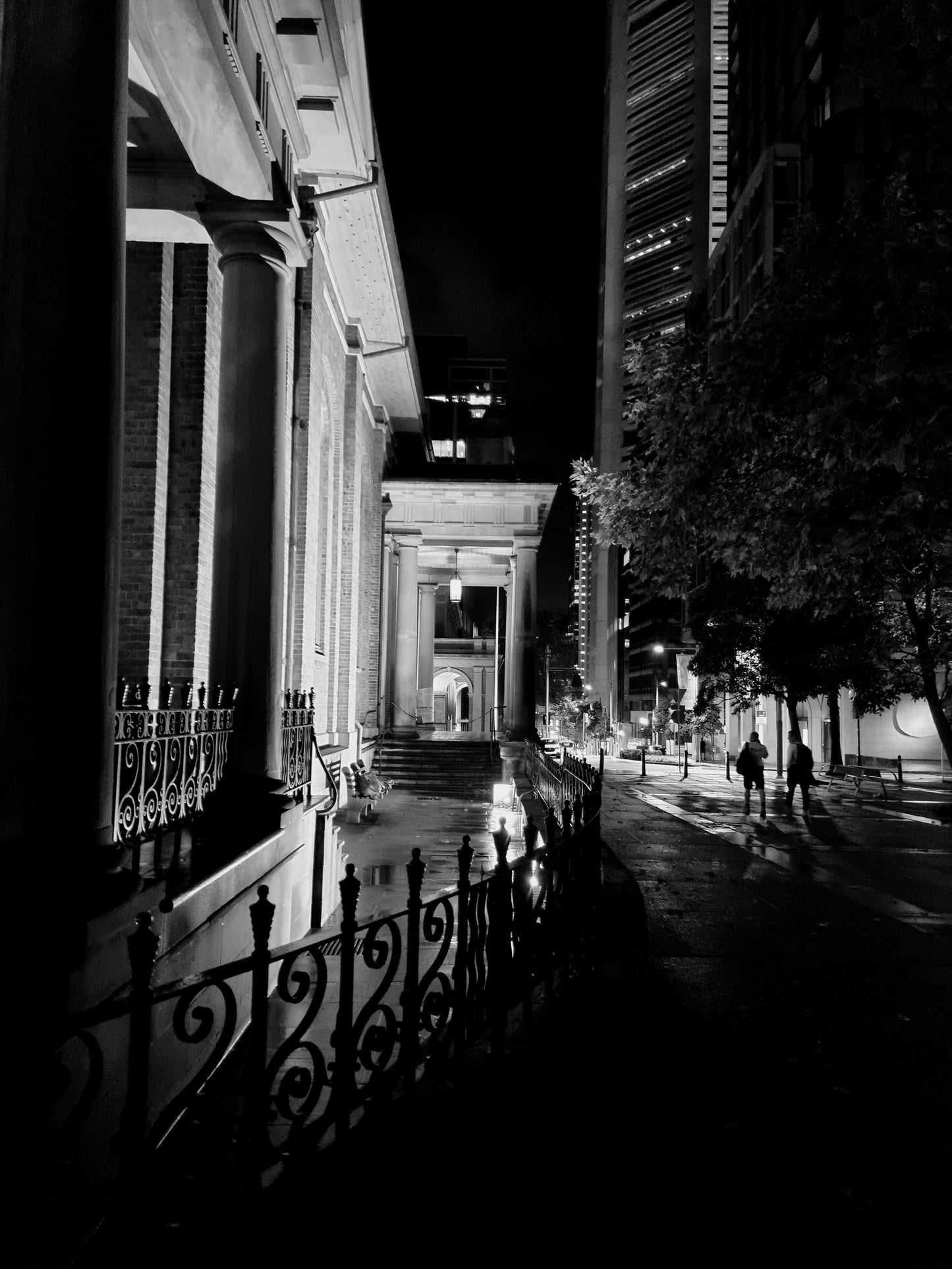 Black and white photo of the ornate iron fencing, curbing around St James' at dawn twilight.