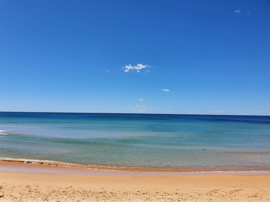 Dee Why Beach. Burnished summer sand. Crystal waters, flat as a lagoon. The blue of the ocean blends to the sky.