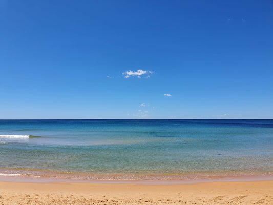 Tranquil waters at Dee Why beach, with the blues reaching to the sky on the horizon.
